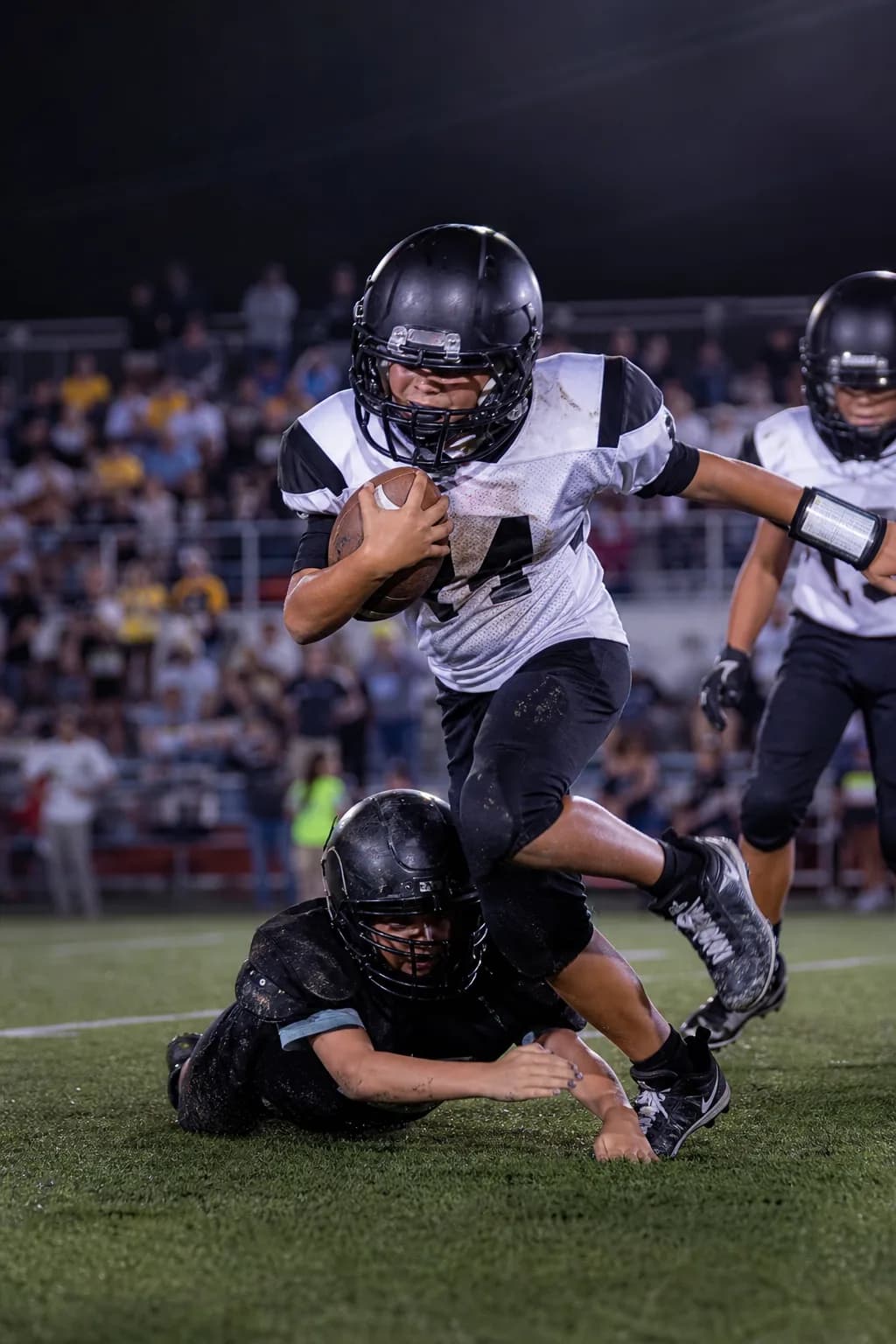 Youth football game under stadium lights